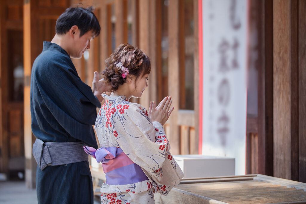 Men and women in yukata bowing in worship